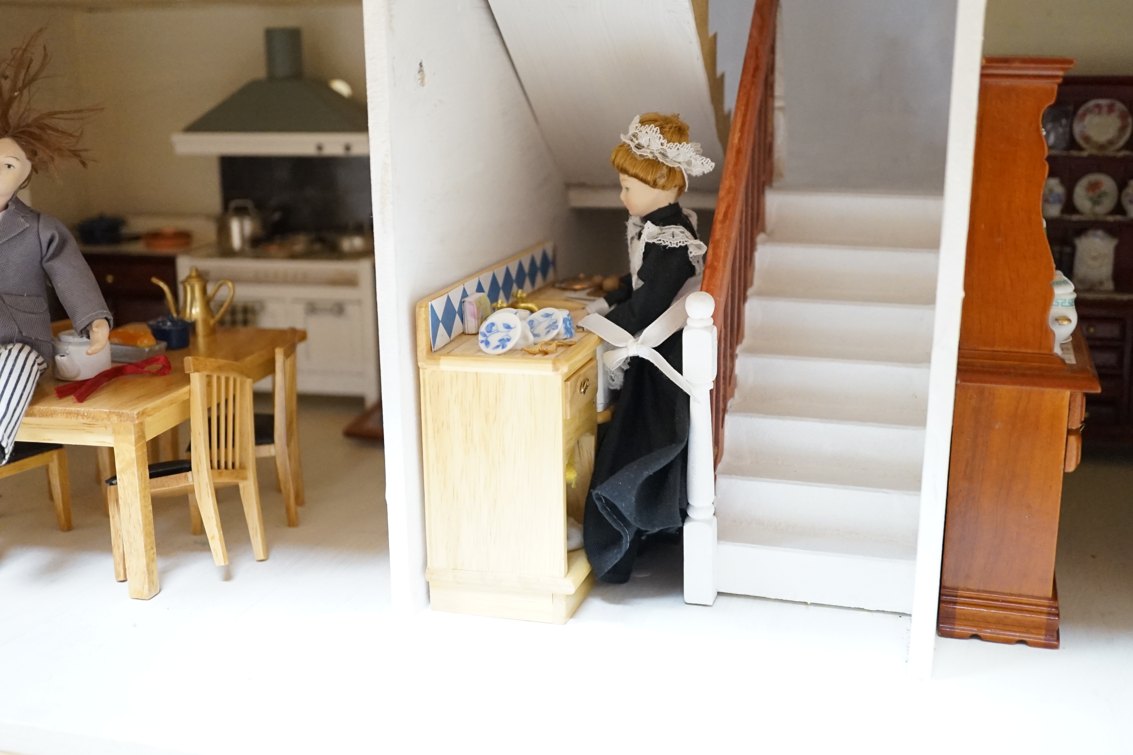 A painted doll's house with dolls and furniture, dolls house 78.5cm wide, 67cm high